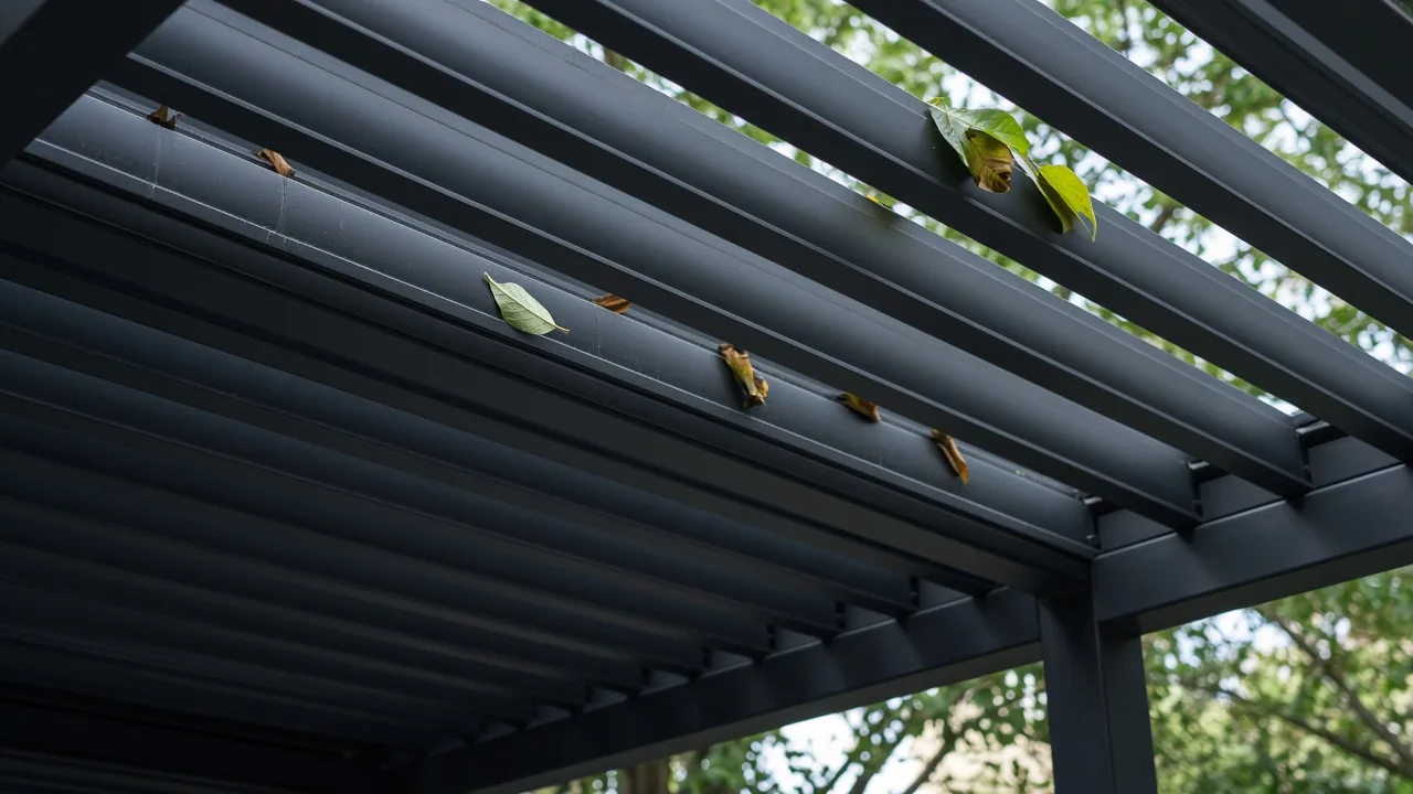 Slightly open aluminum louvers with leaves in the beam channels. Concept visualization · Not a customer installation