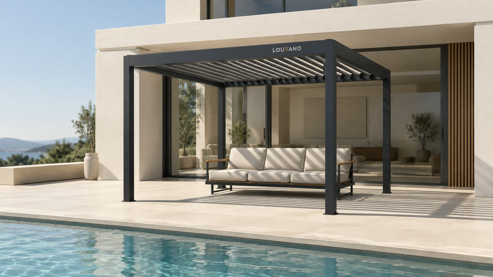 A Louvano pergola beside a stone house and outdoor sofa. Concept visualization · Not a customer installation
